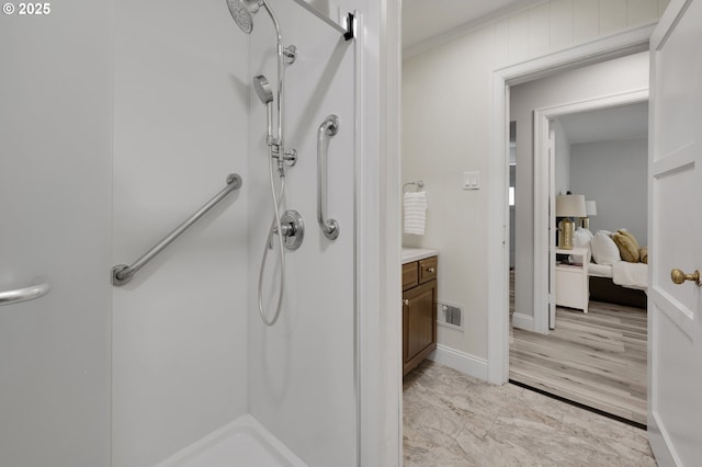 bathroom with a shower, ornamental molding, marble look tile flooring, vanity, and baseboards