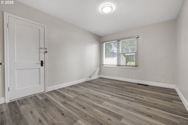 empty room with baseboards and wood finished floors