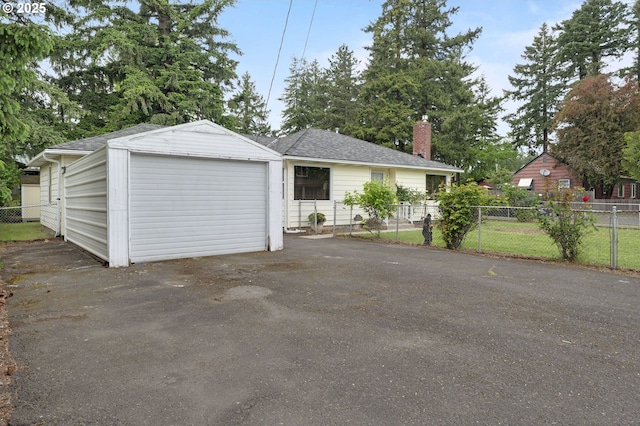 view of front of home featuring driveway, a chimney, fence, a garage, and a shingled roof