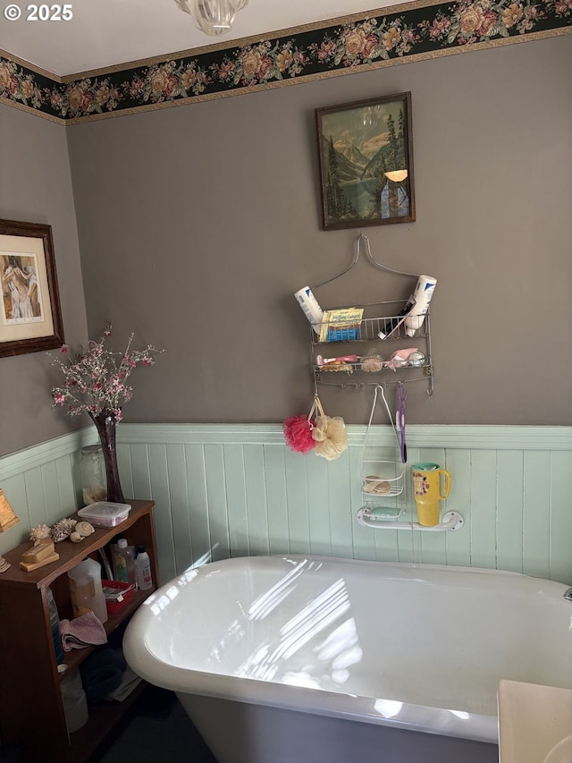 full bathroom featuring wainscoting and a freestanding bath