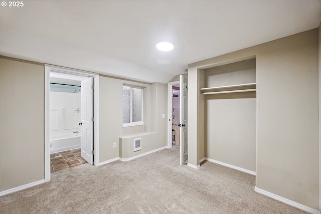 unfurnished bedroom featuring carpet, a closet, baseboards, and connected bathroom