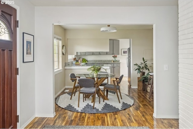 dining space featuring dark wood-style floors and baseboards
