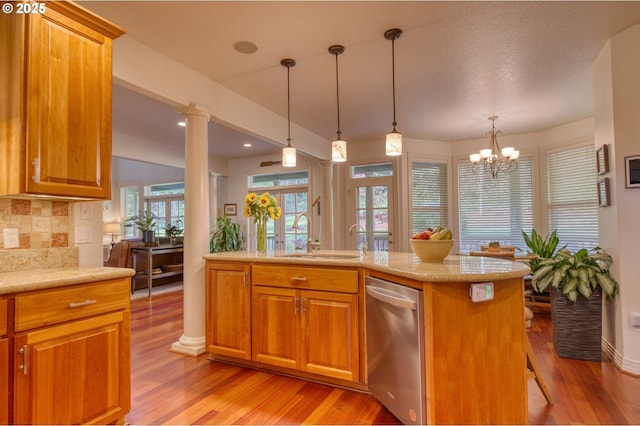 kitchen with light wood-style flooring, backsplash, a sink, and brown cabinetry