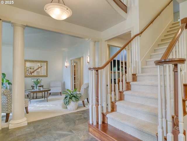 staircase with carpet floors and ornate columns