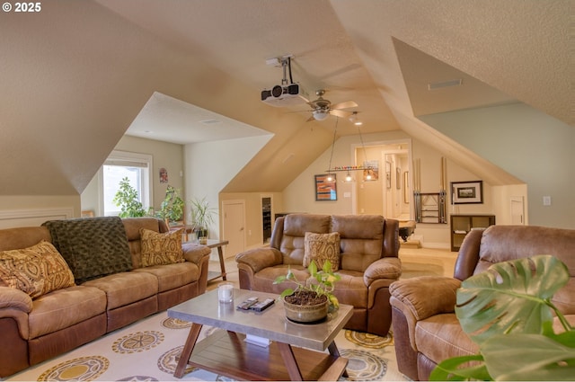 living area featuring visible vents, vaulted ceiling, a textured ceiling, and ceiling fan