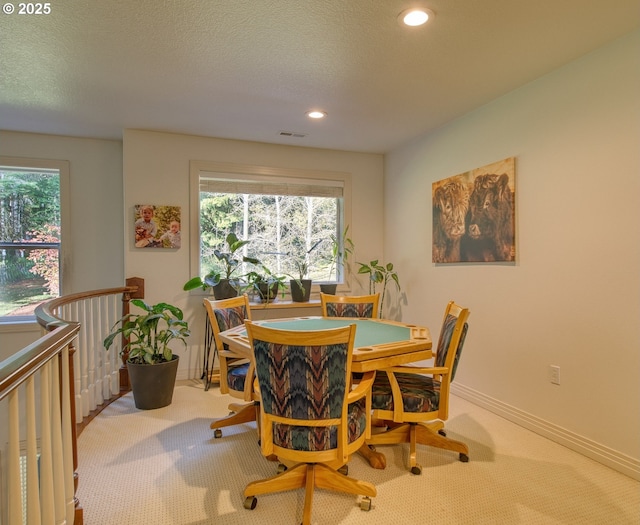 dining room featuring a wealth of natural light, visible vents, a textured ceiling, and carpet flooring