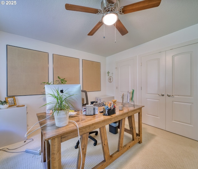 home office featuring light carpet and a ceiling fan