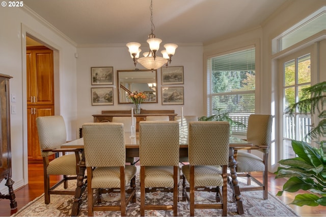 dining area featuring a notable chandelier, wood finished floors, and crown molding