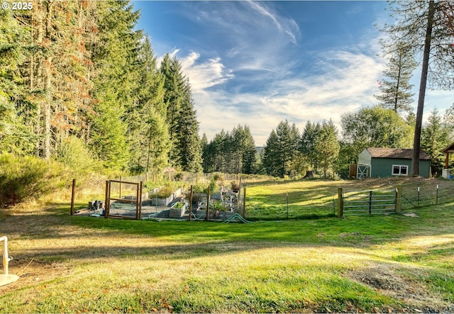 exterior space featuring a vegetable garden, fence, and a lawn