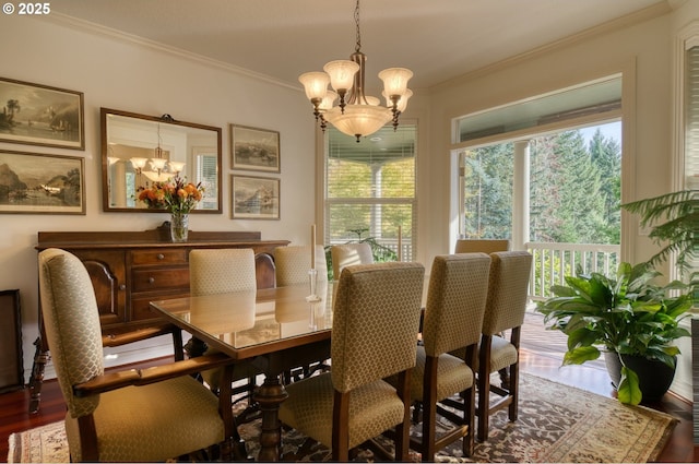 dining room with a chandelier, ornamental molding, and wood finished floors