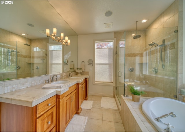 bathroom with a stall shower, a garden tub, a sink, and double vanity