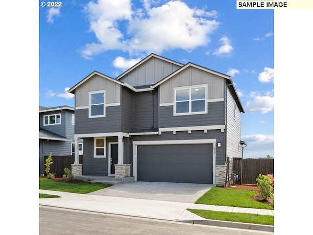 craftsman inspired home with concrete driveway, board and batten siding, fence, a garage, and stone siding