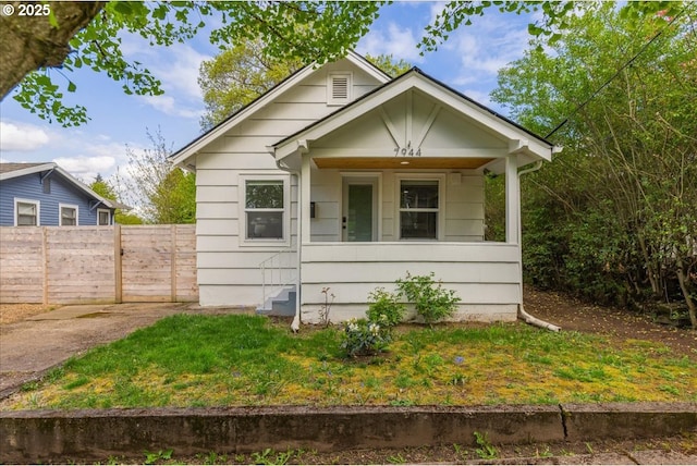 bungalow-style house with fence and covered porch