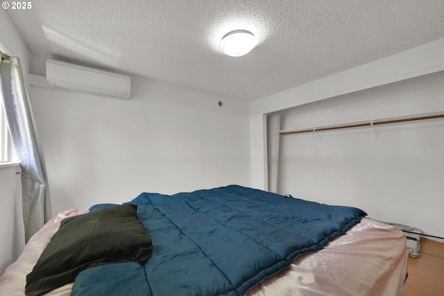 1438 Quaker St, Eugene, OR 97402 - bedroom featuring a wall mounted air conditioner, a textured ceiling, wood finished floors, attic access, and a closet