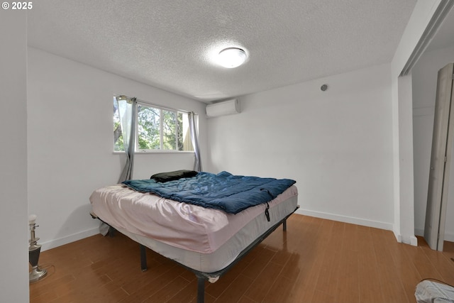 1438 Quaker St, Eugene, OR 97402 - bedroom featuring a wall mounted air conditioner, a textured ceiling, wood finished floors, and baseboards