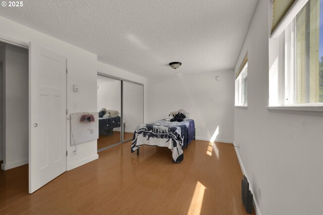1438 Quaker St, Eugene, OR 97402 - bedroom with a closet, wood finished floors, a textured ceiling, and baseboards