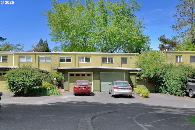 1438 Quaker St, Eugene, OR 97402 - townhome / multi-family property featuring a garage, asphalt driveway, and stucco siding
