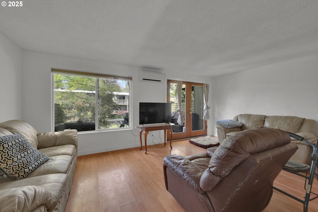 1438 Quaker St, Eugene, OR 97402 - living room with an AC wall unit, hardwood / wood-style floors, a textured ceiling, french doors, and baseboards