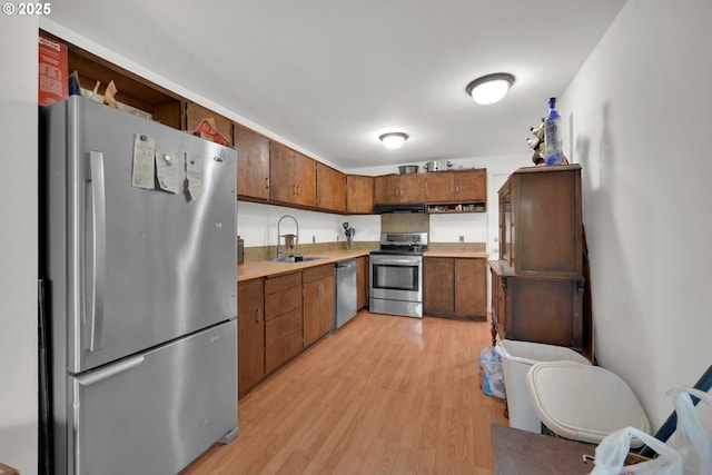 1438 Quaker St, Eugene, OR 97402 - kitchen with appliances with stainless steel finishes, a sink, light wood finished floors, light countertops, and under cabinet range hood