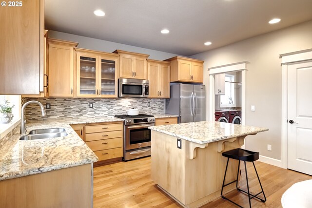 9350 SW Gertz Ln, Tualatin, OR 97062 - kitchen with stainless steel appliances, washing machine and dryer, a sink, light brown cabinetry, and recessed lighting
