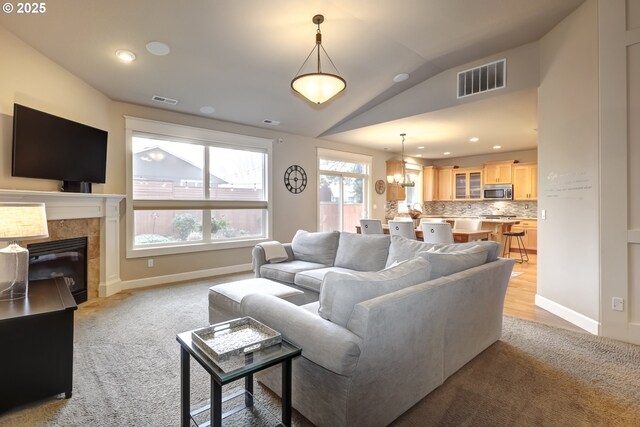 9350 SW Gertz Ln, Tualatin, OR 97062 - living room with lofted ceiling, a chandelier, baseboards, light colored carpet, and a tiled fireplace