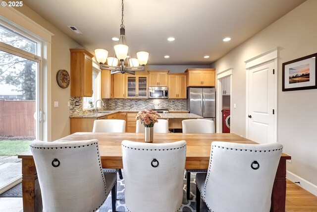 9350 SW Gertz Ln, Tualatin, OR 97062 - dining area featuring a chandelier, light wood-style flooring, recessed lighting, washer / clothes dryer, and baseboards