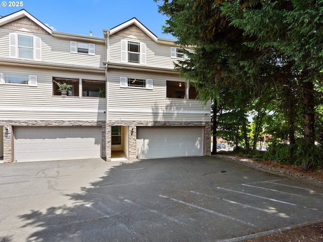 12130 NE Fremont St Unit 4, Portland, OR 97220 - view of front of home featuring stone siding, driveway, and an attached garage