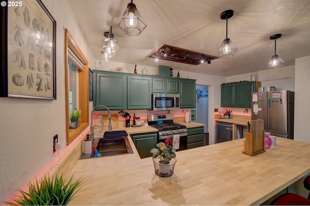 82548 Vinemaple Rd, Seaside, OR 97138 - kitchen featuring appliances with stainless steel finishes, a textured ceiling, a peninsula, wood counters, and green cabinets
