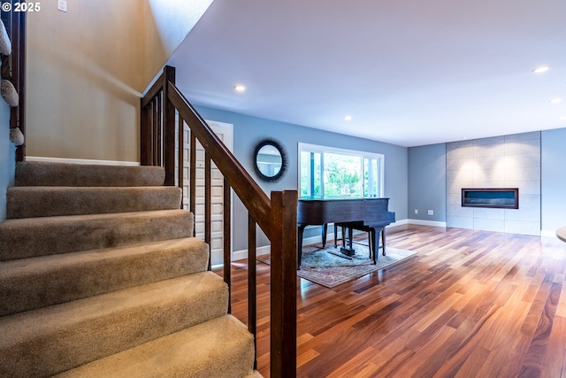6900 SW Preslynn Dr, Portland, OR 97225 - stairs featuring wood finished floors, baseboards, a tile fireplace, and recessed lighting