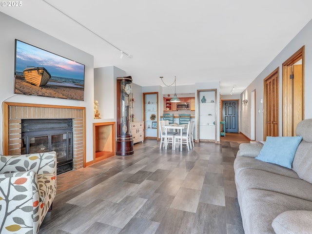 1 3rd St Unit 204, Astoria, OR 97103 - living room with rail lighting, wood finished floors, and a brick fireplace
