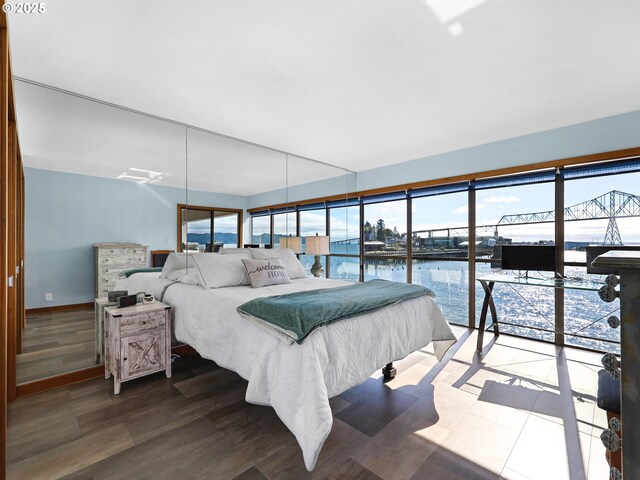 1 3rd St Unit 204, Astoria, OR 97103 - bedroom featuring a water view, wood finished floors, and baseboards