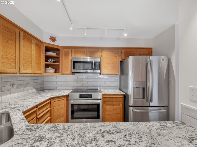 1 3rd St Unit 204, Astoria, OR 97103 - kitchen featuring appliances with stainless steel finishes, light stone countertops, decorative backsplash, and open shelves
