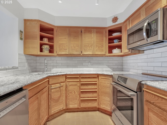 1 3rd St Unit 204, Astoria, OR 97103 - kitchen with appliances with stainless steel finishes, open shelves, a sink, and light stone counters