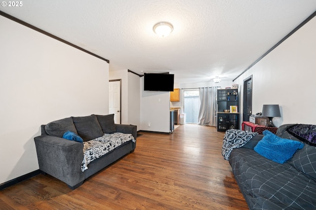 living room with baseboards, a textured ceiling, and wood finished floors