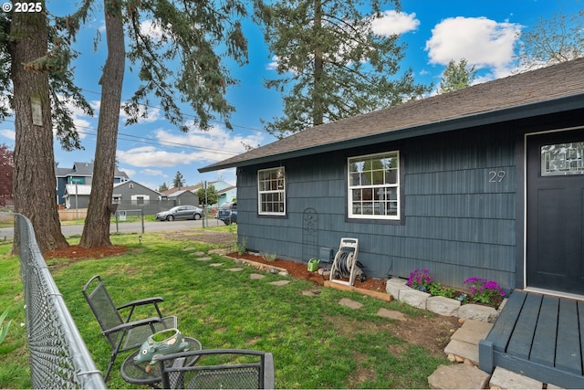 view of property exterior with fence and a yard