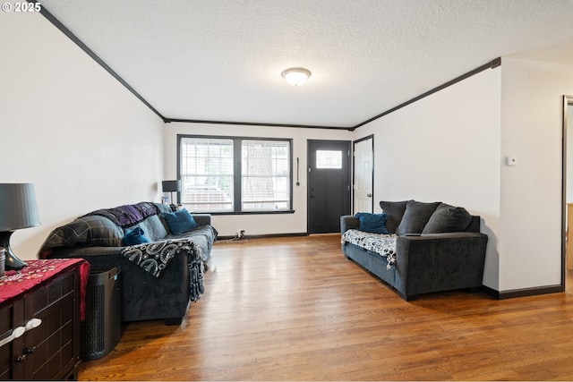 living room featuring crown molding, baseboards, a textured ceiling, and wood finished floors