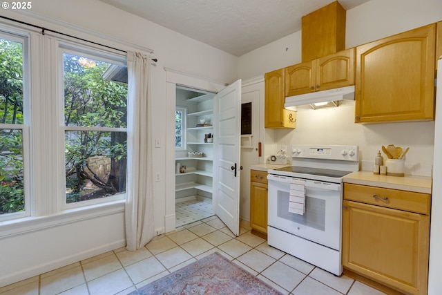 8052 NE Couch St, Portland, OR 97213 - kitchen with white electric range oven, under cabinet range hood, light tile patterned floors, and light countertops