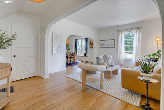 8052 NE Couch St, Portland, OR 97213 - living area with arched walkways and light wood-style flooring