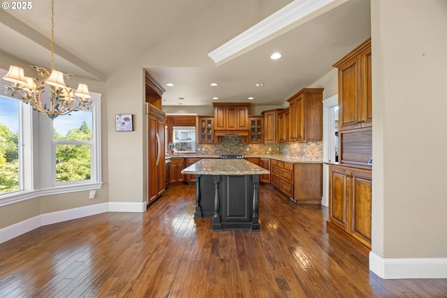 2130 S 26th Ave, Ridgefield, WA 98642 - kitchen featuring brown cabinetry, vaulted ceiling, a chandelier, tasteful backsplash, and a kitchen island