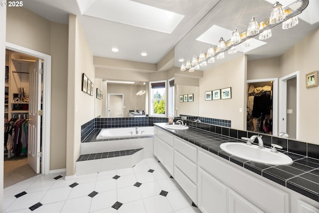 2130 S 26th Ave, Ridgefield, WA 98642 - bathroom featuring a walk in closet, double vanity, a garden tub, a skylight, and recessed lighting