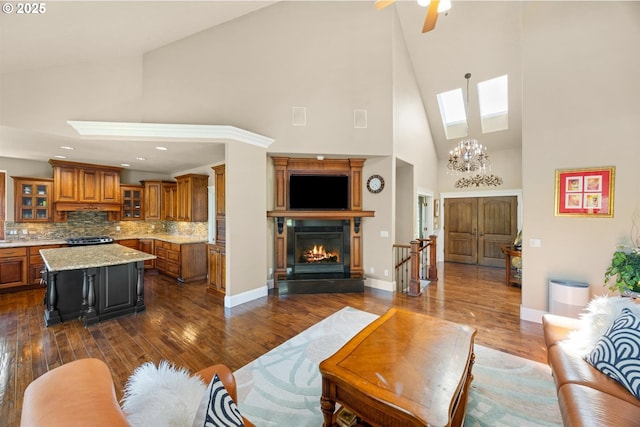 2130 S 26th Ave, Ridgefield, WA 98642 - living room featuring a skylight, high vaulted ceiling, dark wood finished floors, a glass covered fireplace, and a ceiling fan