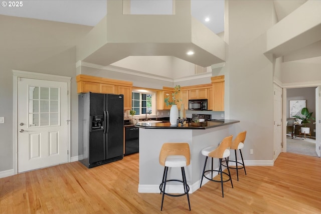 15564 S Neibur Rd, Oregon City, OR 97045 - kitchen featuring light brown cabinetry, a sink, a peninsula, a towering ceiling, and black appliances