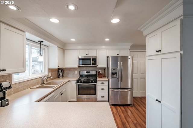 kitchen with sink, pendant lighting, white cabinets, and stainless steel appliances