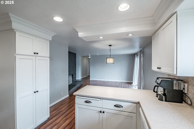 kitchen with pendant lighting, white cabinets, dark hardwood / wood-style flooring, and a fireplace