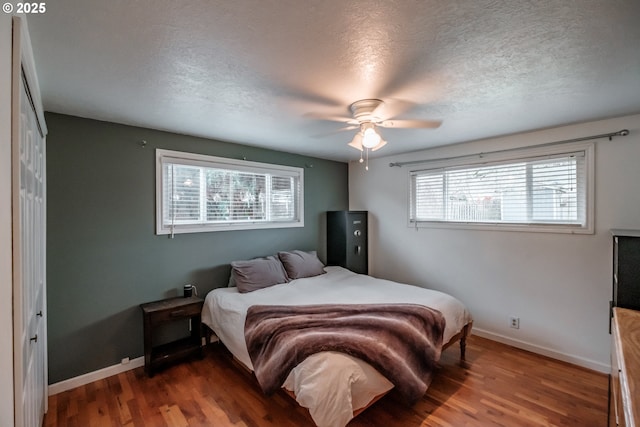 bedroom featuring ceiling fan, a textured ceiling, hardwood / wood-style flooring, and a closet