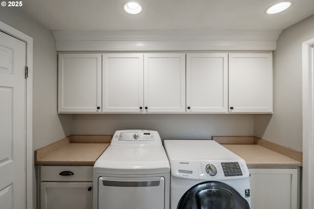 washroom with cabinets and washing machine and clothes dryer