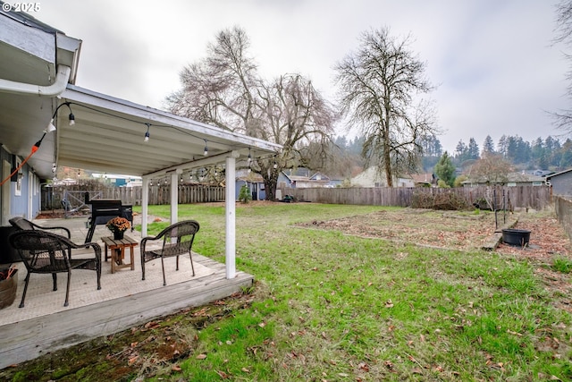 view of yard featuring a wooden deck and a fire pit