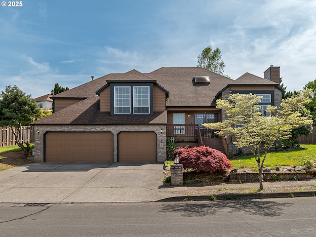 view of front facade with concrete driveway, fence, a shingled roof, and a garage