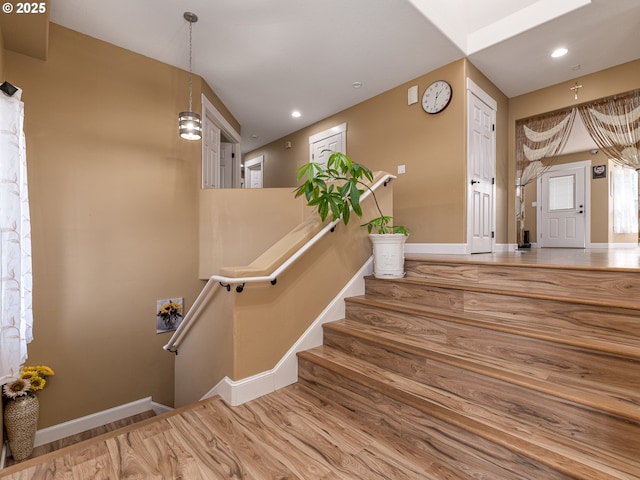stairway featuring baseboards, recessed lighting, and wood finished floors