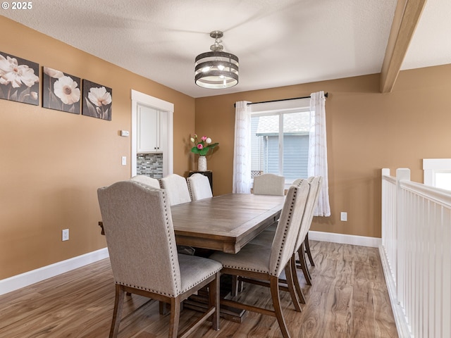 dining space with an inviting chandelier, light wood-style floors, and baseboards